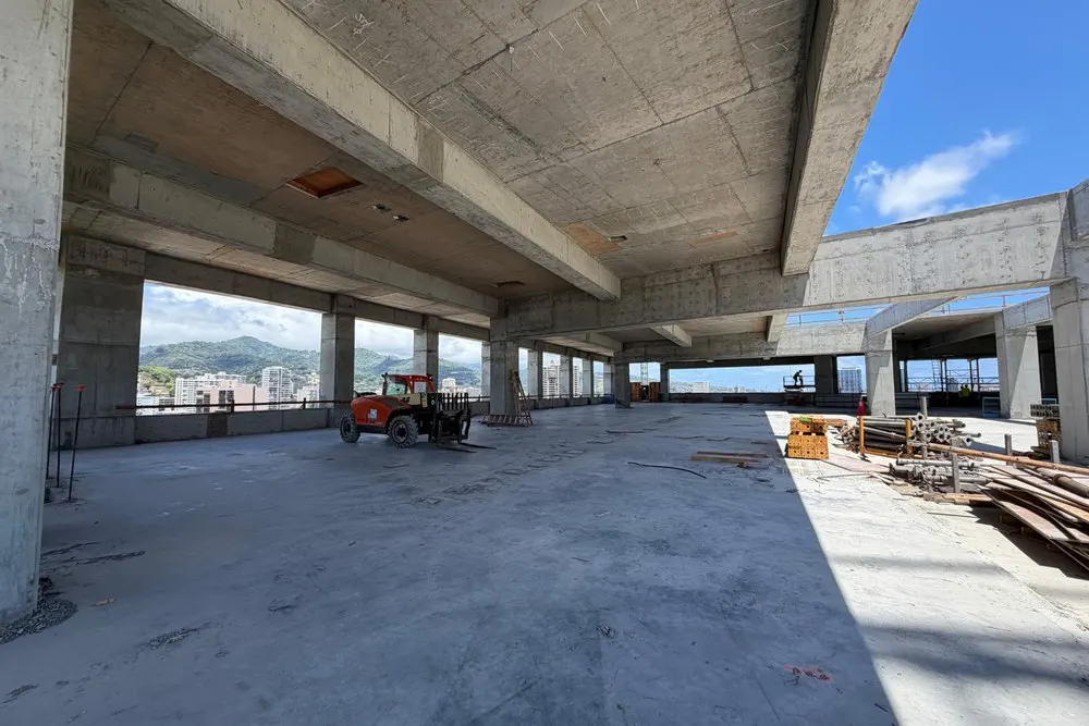Sunlit open floor area with construction materials and a utility vehicle.