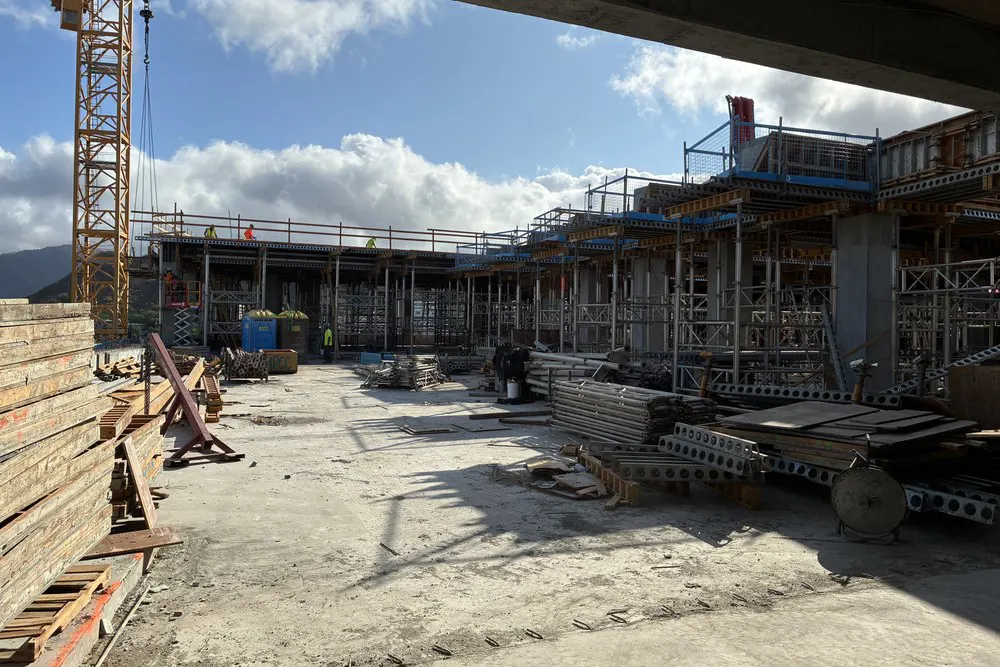 Open rooftop garden area with temporary supports and construction materials.