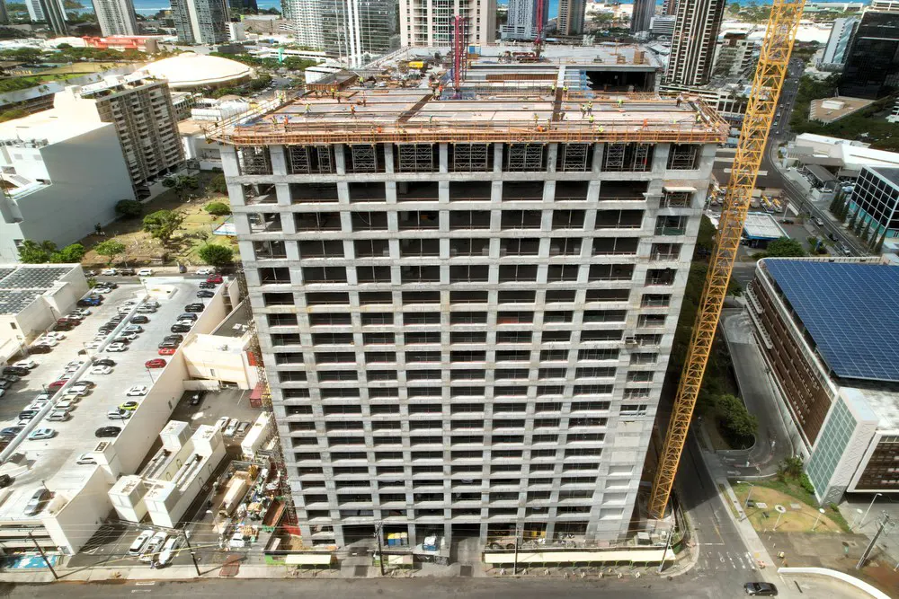 Aerial front view of the parking building with a tower crane alongside it.