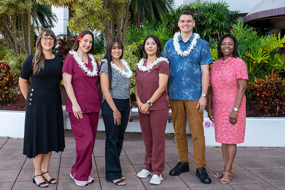 Group shot of Pali Momi scholarship winners wearing lei, alongside leadership.