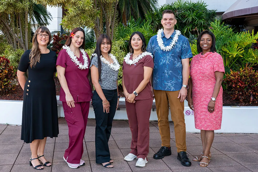 Group shot of Pali Momi scholarship winners wearing lei, alongside leadership.
