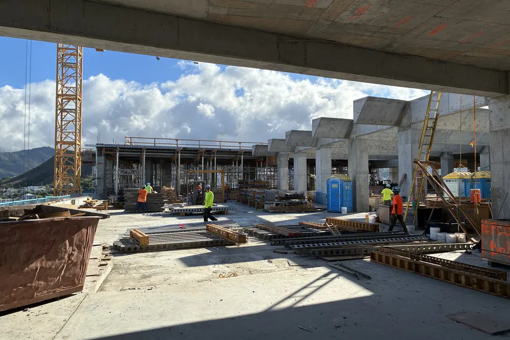 Crew members work among forms, supports, and trellis beams on Level 20.