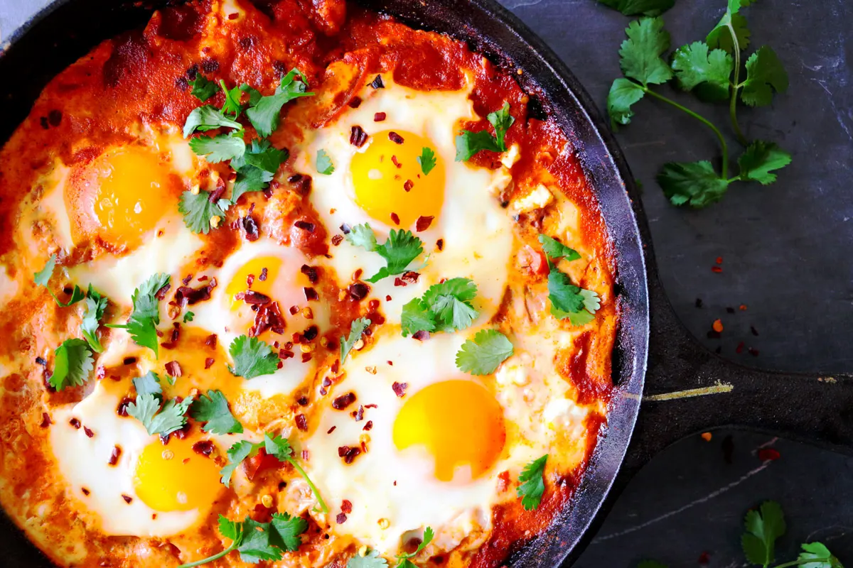 Shakshuka baked in a cast iron skillet and topped with cilantro.