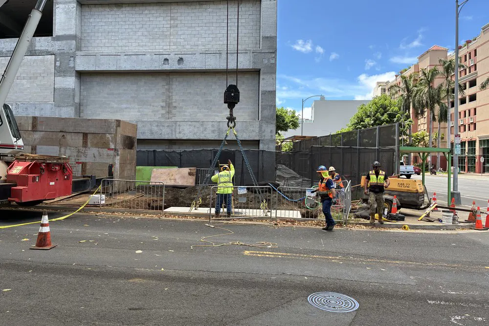 Crew members install a utility manhole along Kealamakai Street.