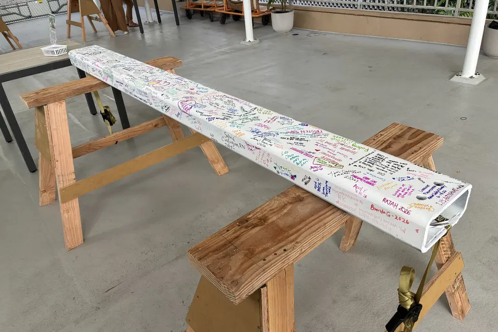 Colorful signatures and messages cover the construction beam.