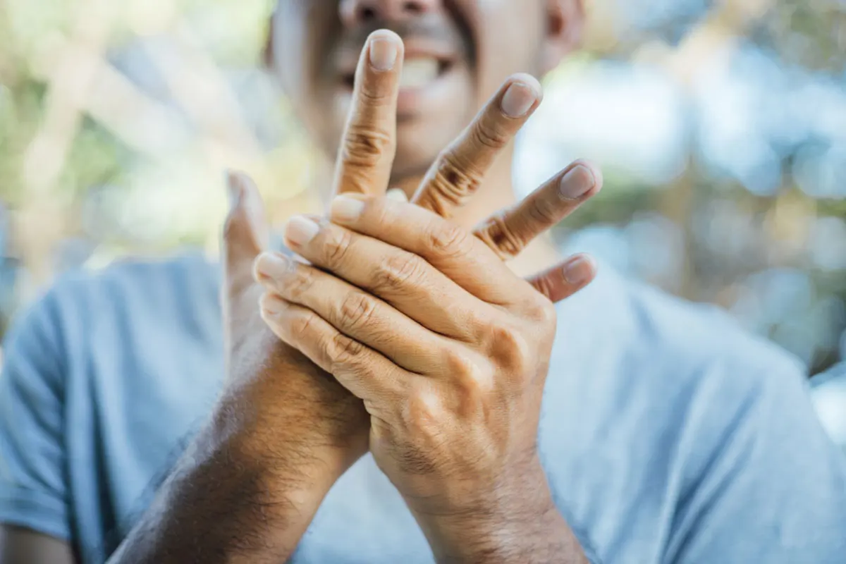 man holds hand in pain