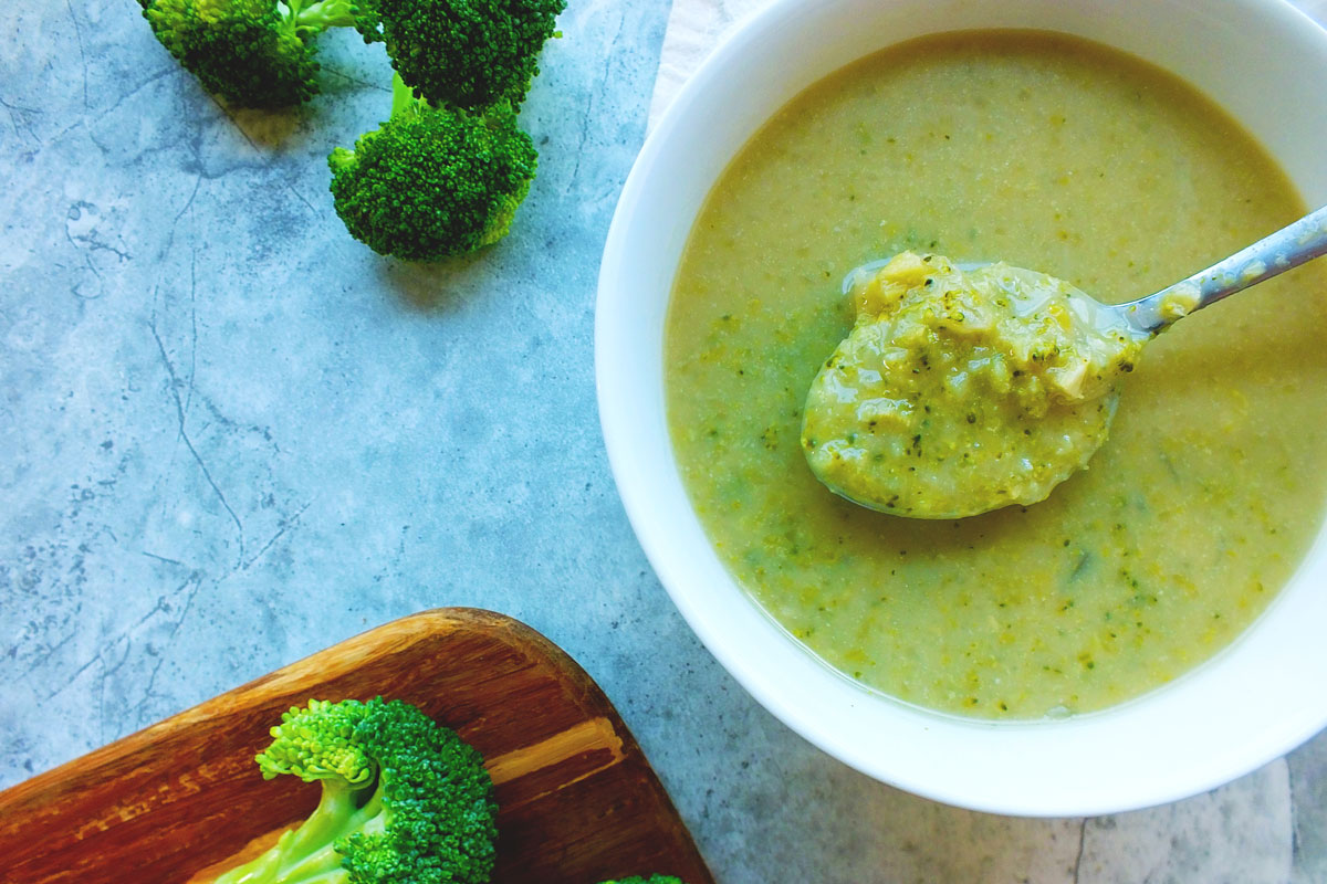 Creamy green soup in a white bowl.