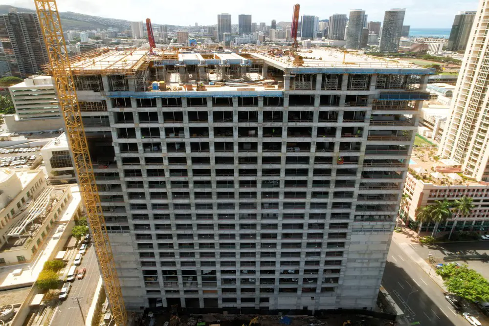 Aerial front view of the parking building with rooftop work underway.